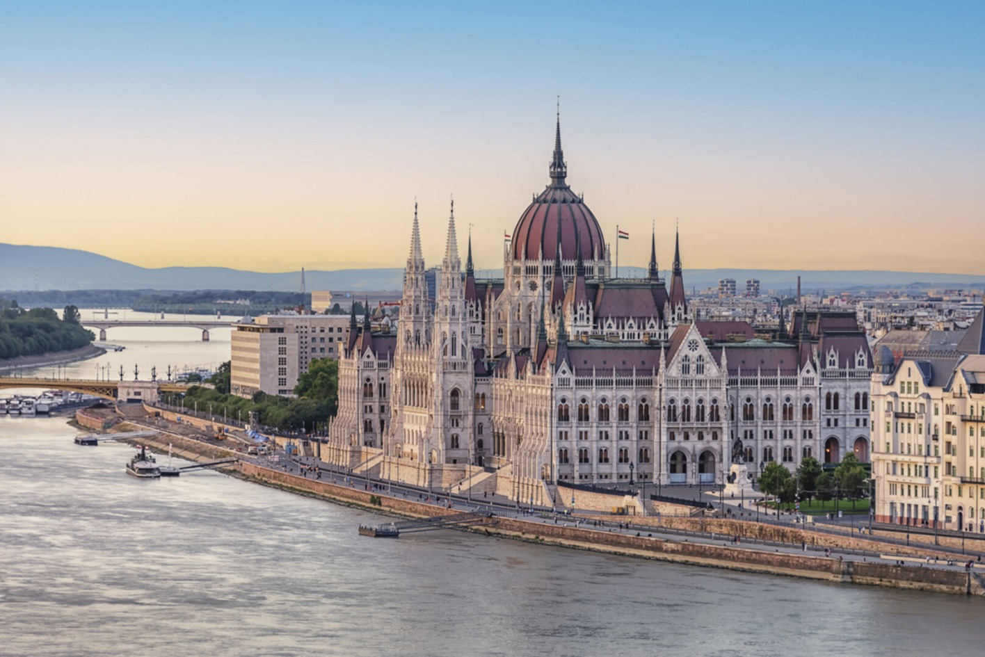 Ein Parlamentsgebäude mit Kuppeln direkt an einem Fluss