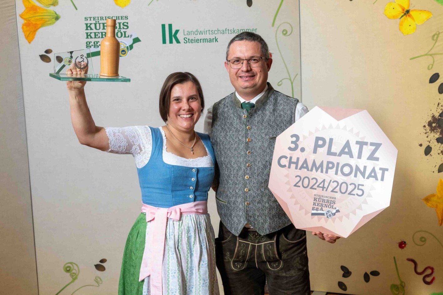 Mann und Frau in Tracht halten Schilder in die Höhe