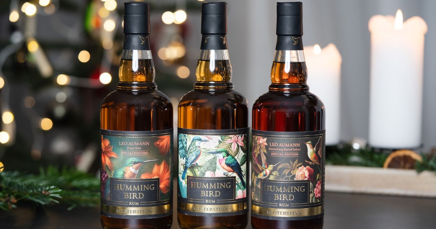 Drei Flaschen Rum mit weihnachtlichem Tannenreisig