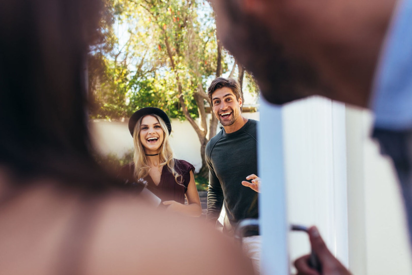 Paar öffnet Gästen die Tür | Credit: iStock.com/jacoblund