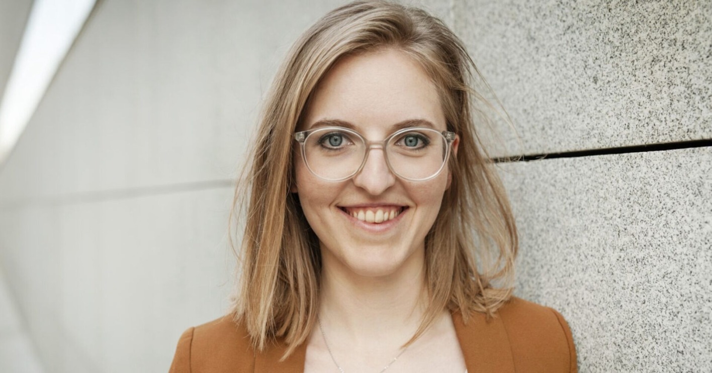 junge Frau mit offenen blonden Haaren und Brille
