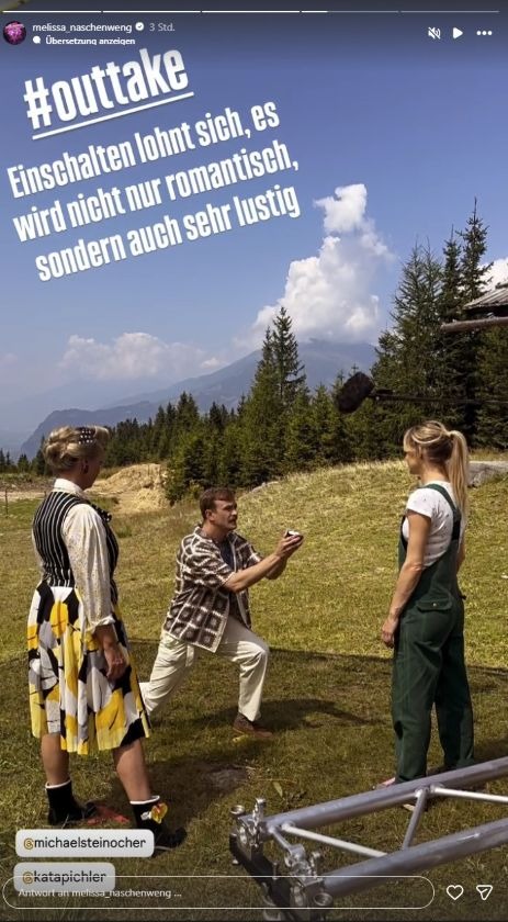 Melissa Naschenweng bei Dreharbeiten in den Bergen: Schauspieler kniet mit Ring vor ihr – Szene aus Film „Herzklang – Zurück zu mir“