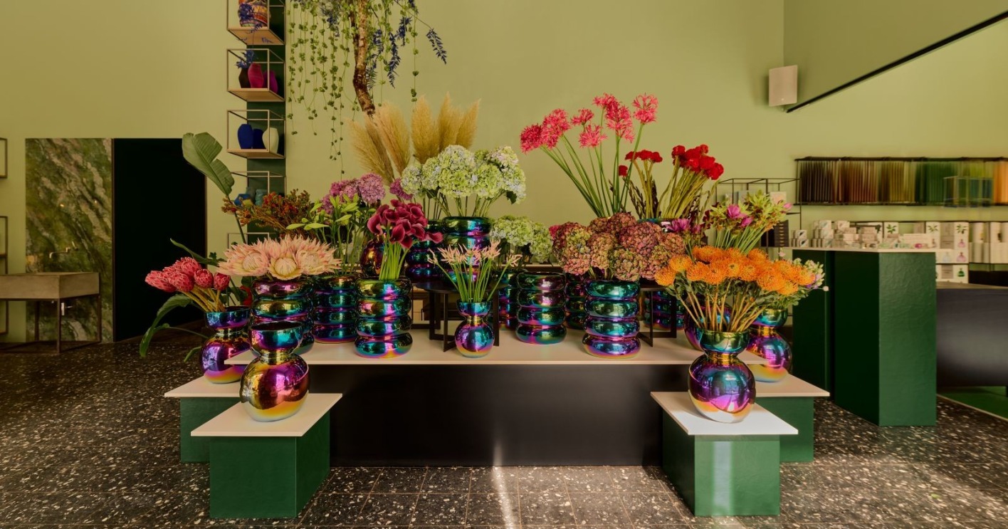 Blumen in regenbogenfarbenen Vasen in einem Blumengeschäft