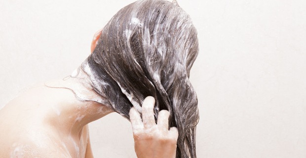 Frau schäumt sich die Haare ein