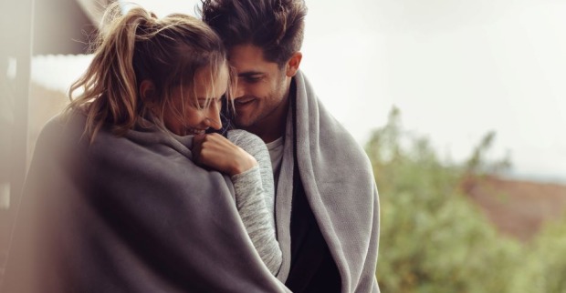 Verliebtes Paar wärmt sich unter einer gemeinsamen Decke gegen die Kälte | Credit: iStock.com/jacoblund