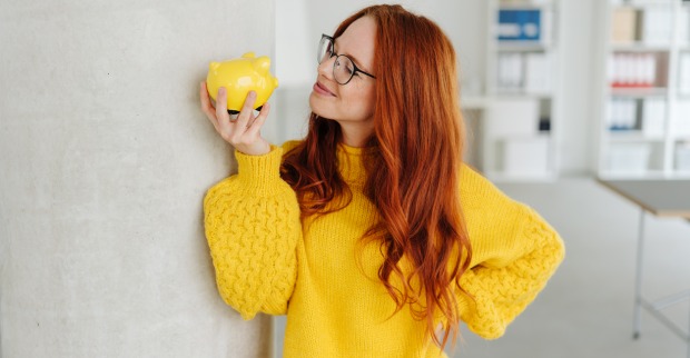 Junge Frau mit Sparschwein | Credit: iStock.com/stockfour