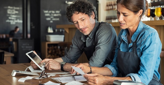 Ein Wirte-Ehepaar mit Rechnungen | Credit: iStock.com/Ridofranz