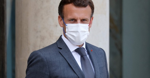Ein Porträt-Foto von Präsident Macron: Er trägt einen grauen Anzug mit Krawatte und einen weißen Mund-Nasen-Schutz.