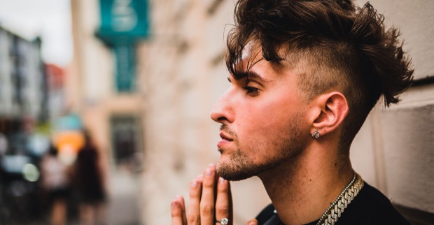 Profilfoto des jungen Rappers Gavis Dean, der an einer Gebäudefassade lehnt