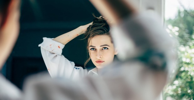 Frau begutachtet sich im Spiegel | Credit: iStock.com/Viktor_Gladkov