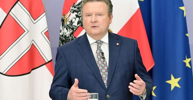 Bürgermeister Michael Ludwig steht vor einer Wien-, Österreich und EU-Flagge und erklärt die Maßnahmen.