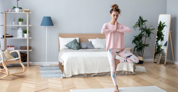Junge Frau beim Yoga in ihrem Schlafzimmer | Credit: iStock.com/PavelIvanov