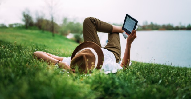 Mann beim Lesen eines E-Books unter freiem Himmel | Credit: iStock.com/nortonrsx