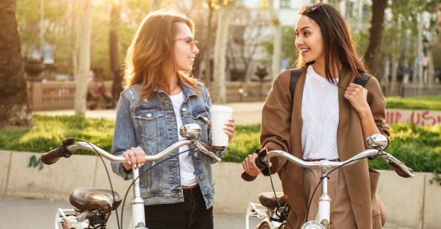 Zwei junge Frauen schieben Fahrräder| Credit: iStock.com/DeanDrobot