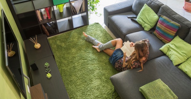 Frau liest im Wohnzimmer ein Buch | Credit: iStock.com/luana rigolli