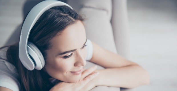 Frau hört entspannt Musik per Kopfhörer | Credit: iStock.com/Deagreez