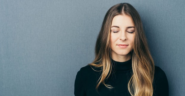 Frau träumt mit geschlossenen Augen vor sich hin | Credit: iStock.com/stockfour