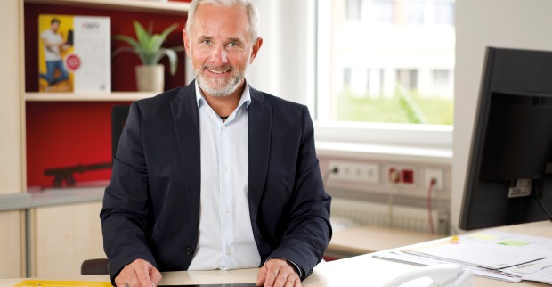 Der Geschäftsführer des bfi, Gottfried Pototschnig, sitzt an seinem Schreibtisch vor einem Tablet-PC