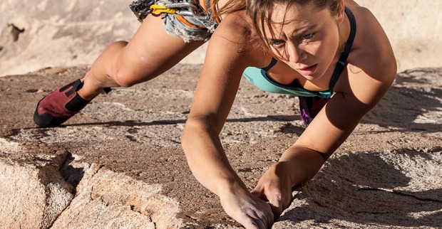 Junge Frau beim Klettern in der Felswand | Credit: iStock.com/gregepperson