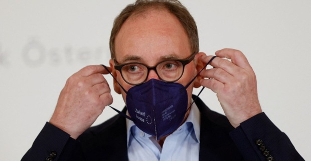 Gesundheitsminister Johannes Rauch setzt eine schwarze FFP2-Maske auf.