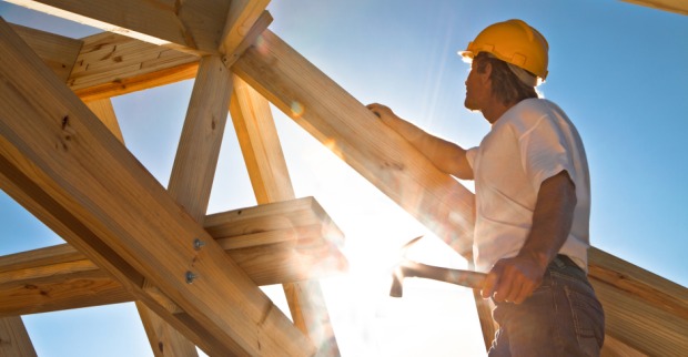 Bauarbeiter fertigt Dachstuhl aus Holz | Credit: iStock.com/sculpies