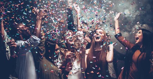 Junge Gruppe an Menschen feiert ausgelassen im Konfetti-Regen | Credit: iStock.com/g-stockstudio
