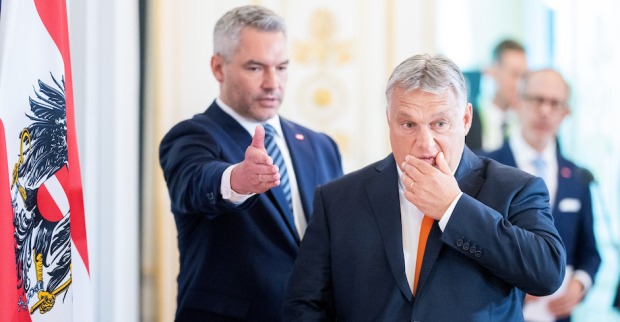 Viktor Orbán fasst sich an den Mund, hinter ihm Karl Nehammer, der den Weg deutet.