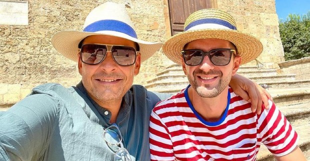 Ein Selfie von Gerald Grosz und seinem Ehemann. Beide tragen Sonnenhüte und Sonnebrillen