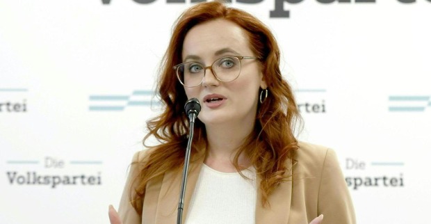Laura Sachslehner vor der Pressewand der ÖVP. Sie spricht in ein Mikrofon