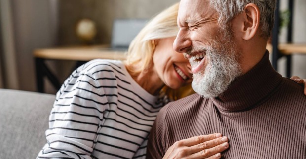 Reiferes Paar lacht gemeinsam auf der Couch | Credit: iStock.com/Inside Creative House