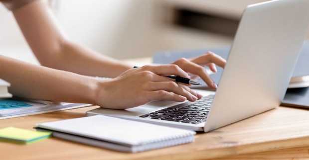 Junge Frau tippt auf ihrem Notebook | Credit: iStock.com/fizkes