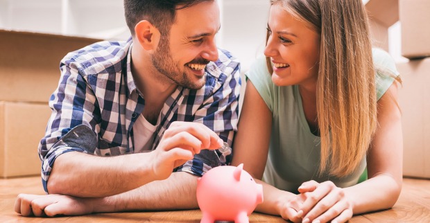 Glückliches Paar mit gemeinsamen Sparschweinchen | Credit: iStock.com/Photodjo