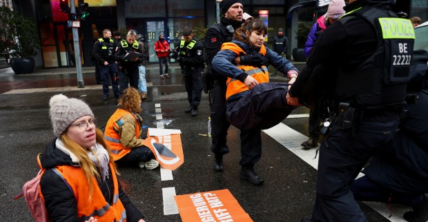 Demonstrantin wird von Polizisten weggetragen