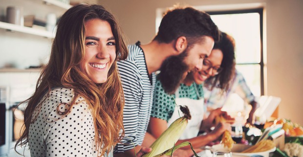 Junge Frauen und Männer beim gemeinsamen Kochen | Credit: iStock.com/FlamingoImages