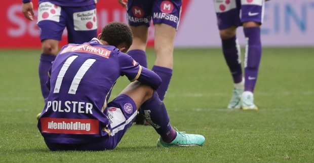 Enttäuschter Austria Wien Spieler sitzt auf dem Spielfeld