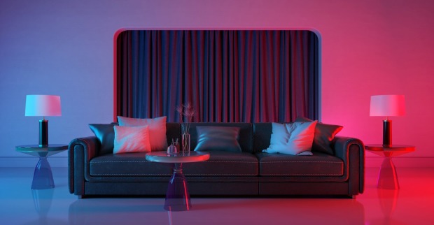 Rotes LED-Licht erhellt eine schwarze Couch | Credit: iStock.com/Ninoon