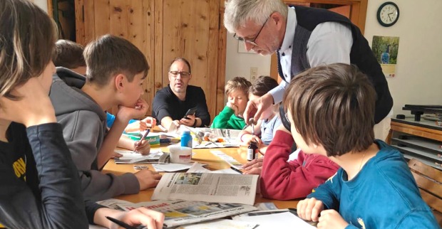 Vereinsgründer Jürgen Peter zeigt im Jugendworkshop, wie Zaubertricks mit Zeitungen vorbereitet werden.