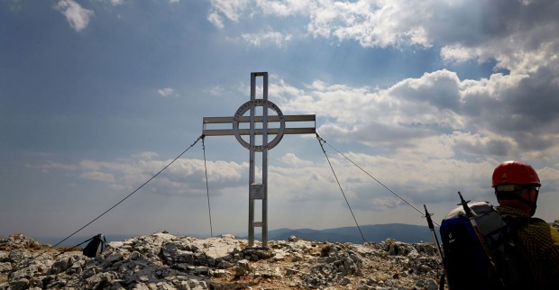 Kletterer steht am Gipfelkreuz | Credit: Hans Ringhofer / picturedesk.com