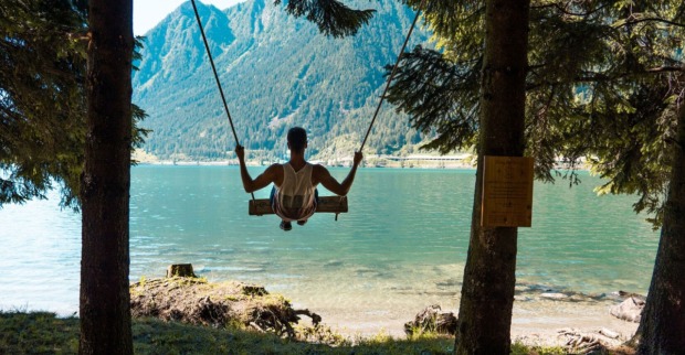 Junger Mann schaukelt man Ufer des Lago di Poschiavo | Credit: Valposchiavo Turismo