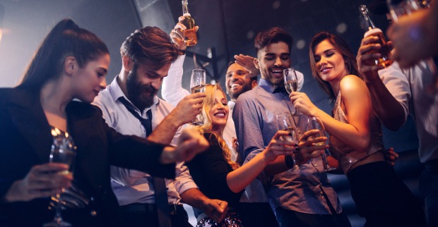 Partypeople mit Bier und Champagner beim Tanzen