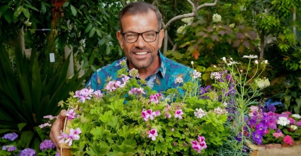 Karl Ploberger hält im Garten eine Holzkiste mit blühenden Sommerblumen | Credit: ORF/Roman Zach-Kiesling