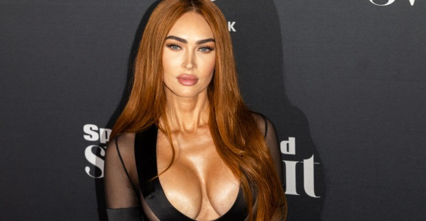 Megan Fox posiert vor schwarzem Hintergrund in einem tief ausgeschnittenem Kleid