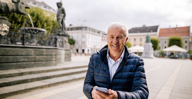 Mann probiert App am Handy vor Lindwurm Klagenfurt aus