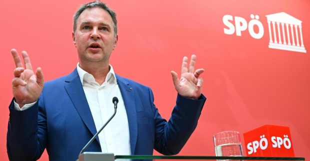 Andi Babler vor der Pressewand der SPÖ. Er spricht und hat die Hände gestikulierend in der Luft.