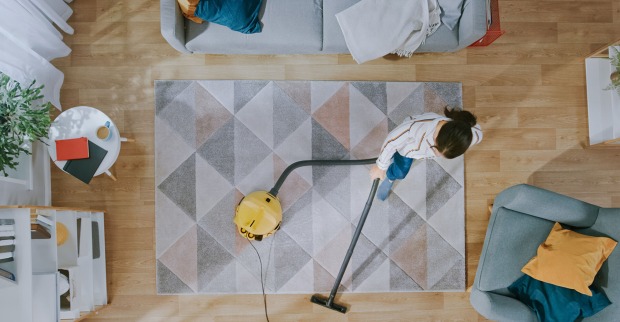 Frau saugt das Wohnzimmer | Credit: iStock.com/gorodenkoff