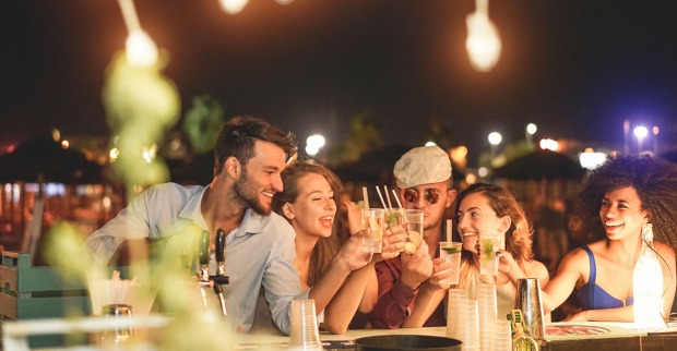 Freunde sitzen an der Bar | Credit: iStock.com/DisobeyArt
