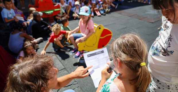 Kinder, die spielen und einen Zettel ausfüllen