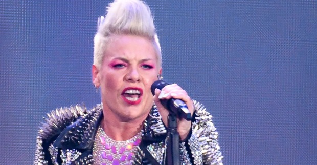Eine Frau mit platinblonden Haaren singt in ein Mikrophon.