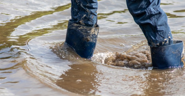 Mit Stiefeln in dreckigem Wasser