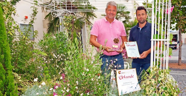 Gerhard Köfer und Daniel Santner mit den Urkunden inmitten von Pflanzen
